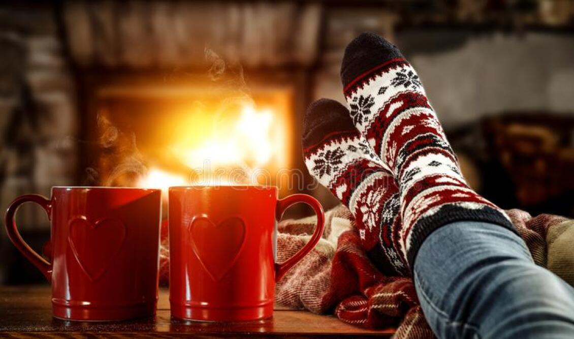 woman-s-legs-christmas-socks-red-mugs-coffee-tea-home-interior-fireplace-dark-wall-background-empty-162994703